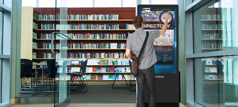 someone using a kiosk touch screen in a library
