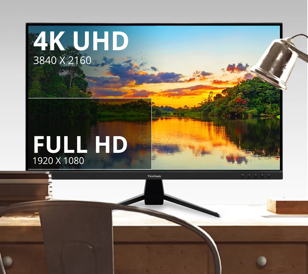 Monitor on a desk showing the difference between Full HD and 4K UHD resolution