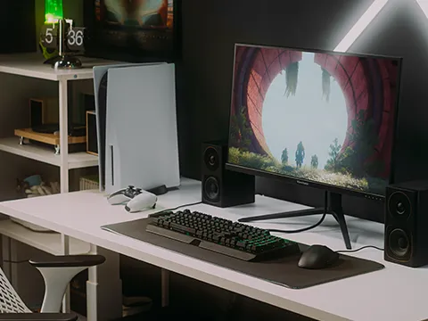 a monitor sitting next to a ps5 on a desk