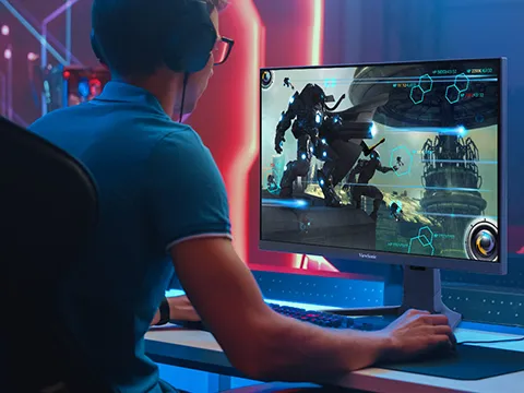 someone playing a computer game on a gaming monitor with headphones on