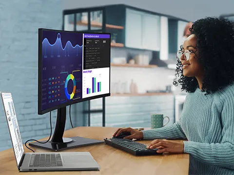 a woman working on a laptop connected to a monitor via usb-c