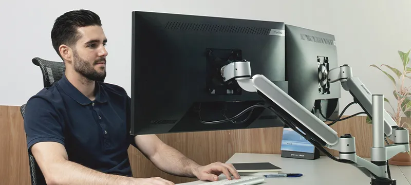 someone using two monitors on a dual mounting arm