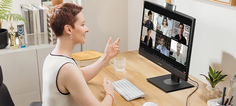 someone on a conference call using the built-in webcam on the monitor