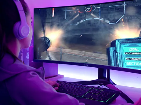 a woman wearing headphones games on an ultrawide display