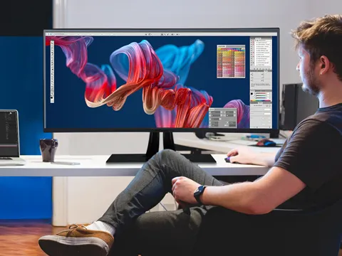 a man using photo editing software on an ultrtrawide display