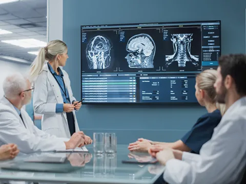 a doctor showing MRI scans to a room of other doctors