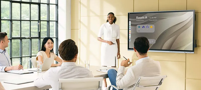 a businesswoman giving a presentation using a viewboard display in a conference room.