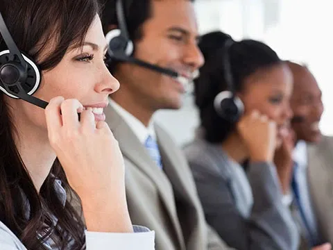 a row of customer support agents with headsets