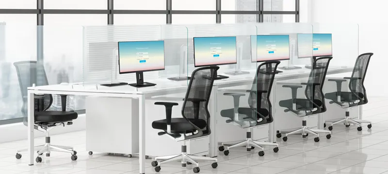a row of monitors and chairs in an office