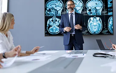 a businessman presenting brain scans to a board room