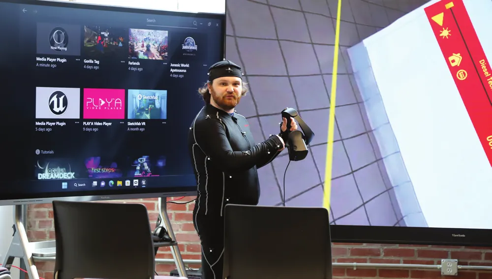 a man in a motion capture suit holding a vr headset
