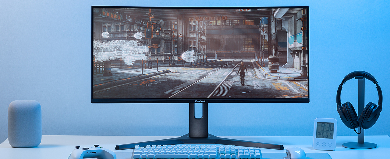 a woman using an ultrawide monitor with multiple windows open while taking notes in a notebook