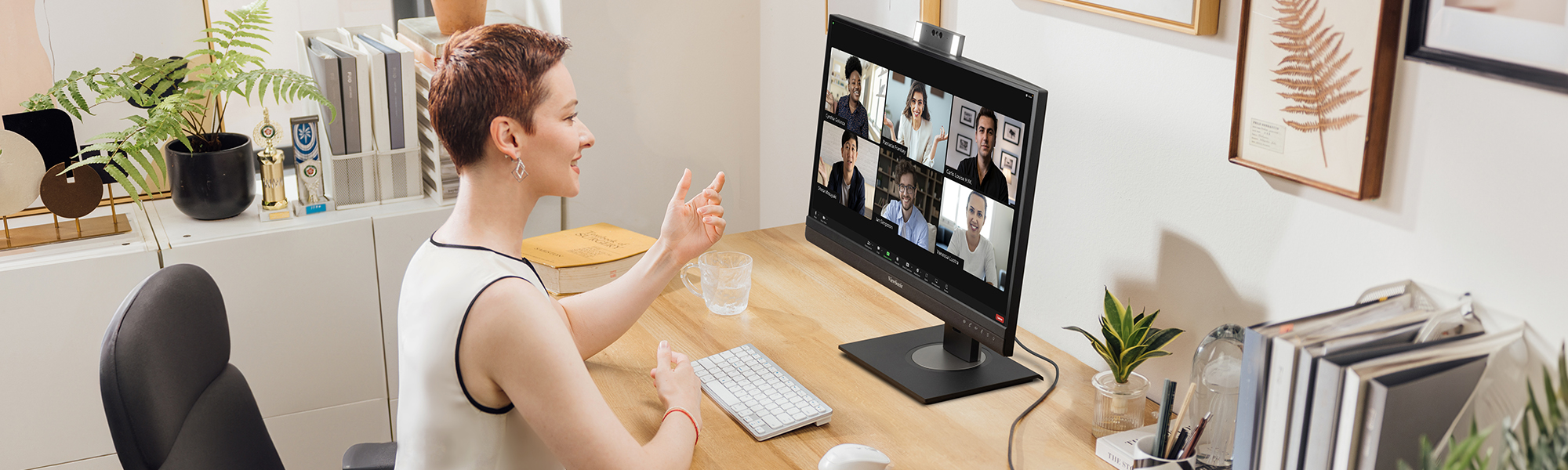 someone on a conference call using the built-in webcam on the monitor